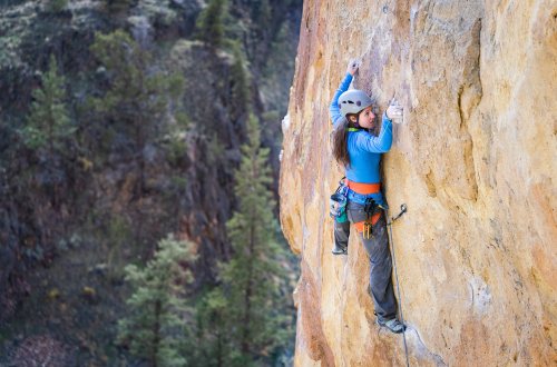 Een vrouw beklimt mer voorzorgsmaatregelen een berg